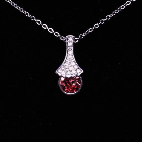 Necklace with a pendant featuring a red gemstone on a black background