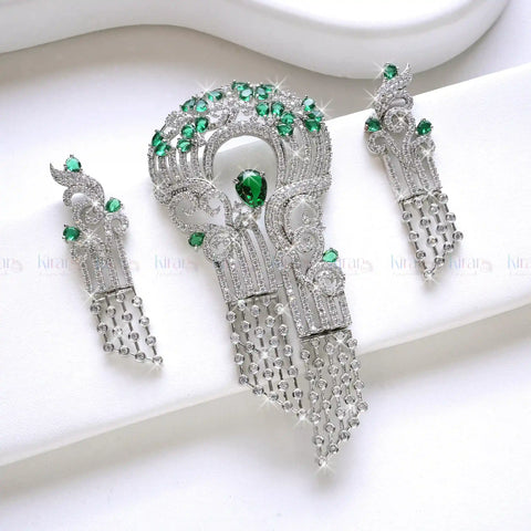 Ornate silver earrings with green gemstones on a white background