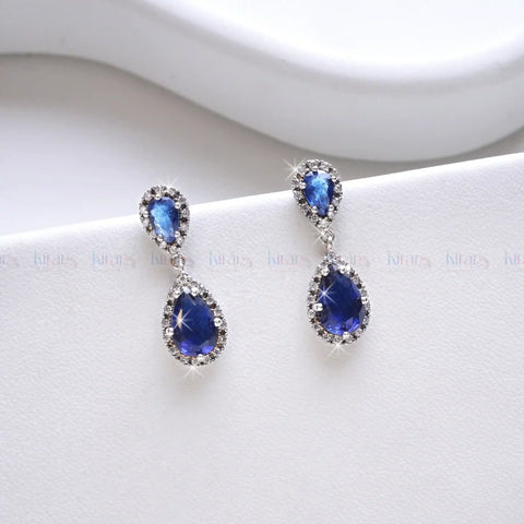 Pair of blue teardrop earrings on a white background