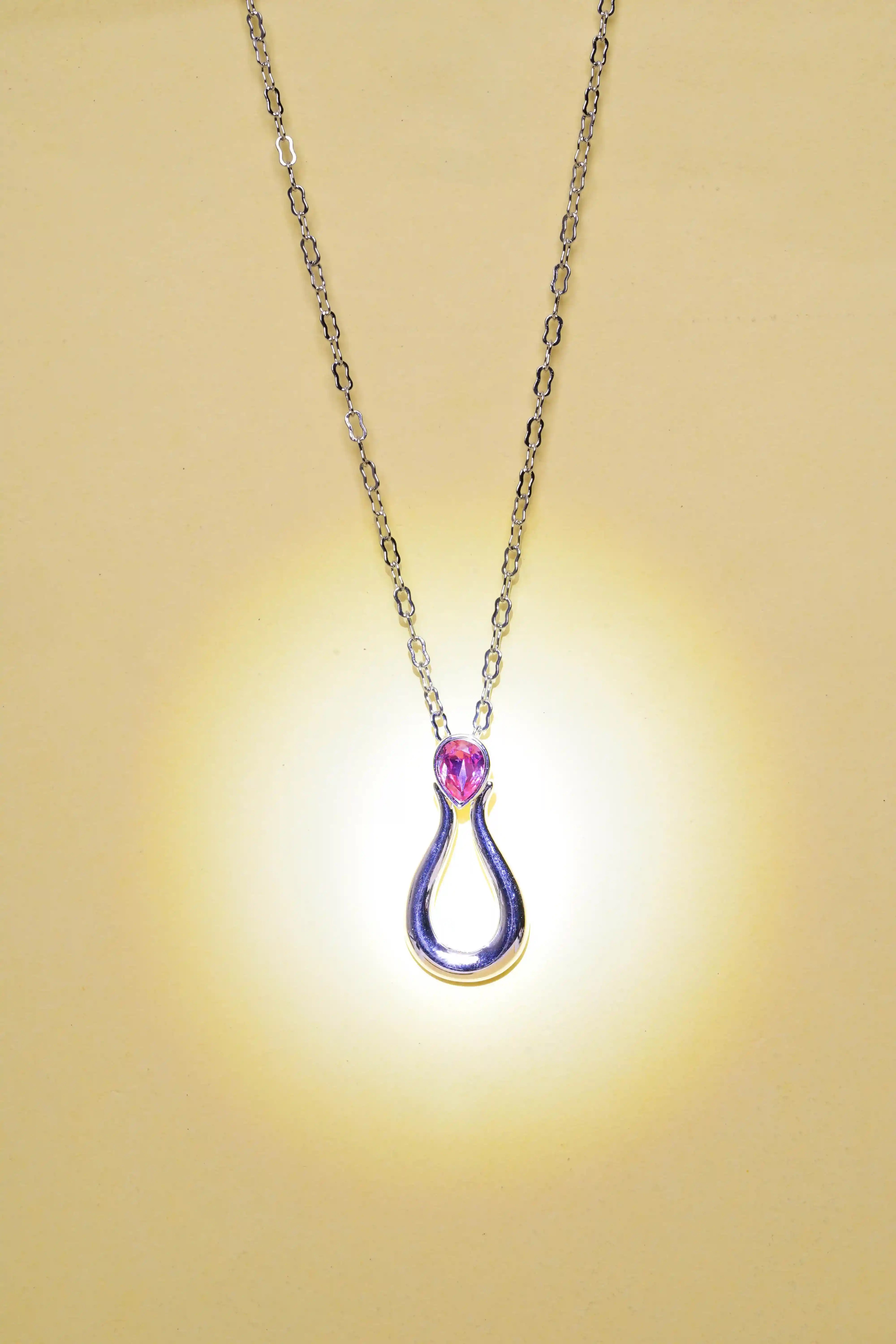 Necklace with a teardrop-shaped pendant on a beige background