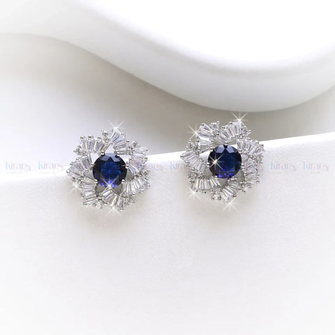 Pair of earrings with blue gemstones and clear stones on a white background