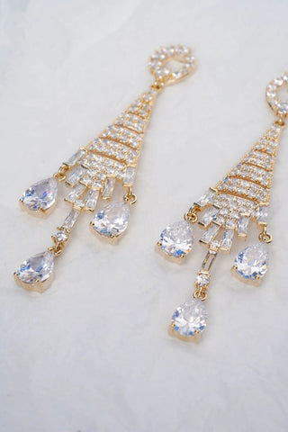 Gold and crystal earrings on a light background