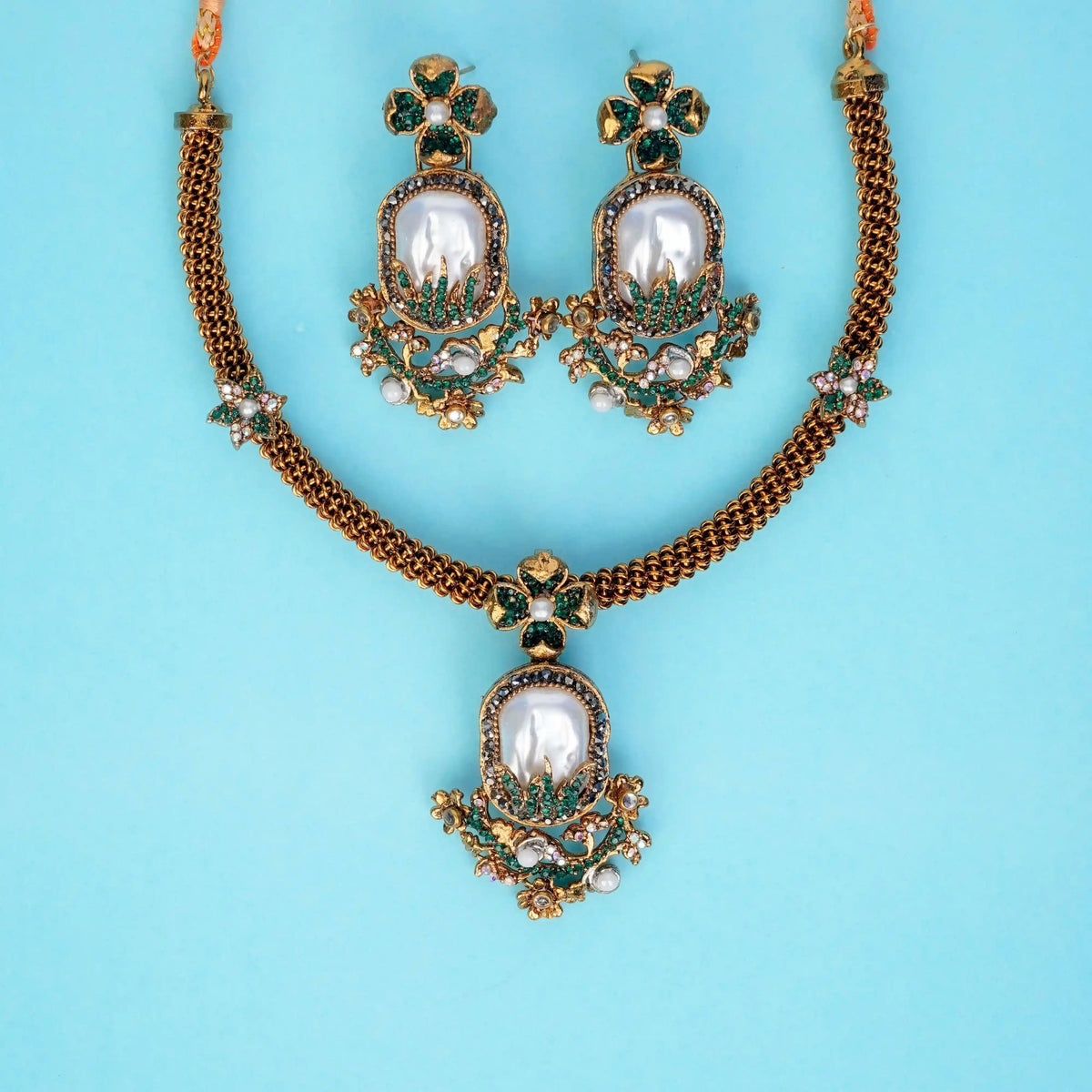 Jewelry set with necklace and earrings on a light blue background