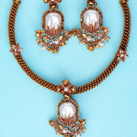 Ornate necklace with pearl-like stones on a light blue background