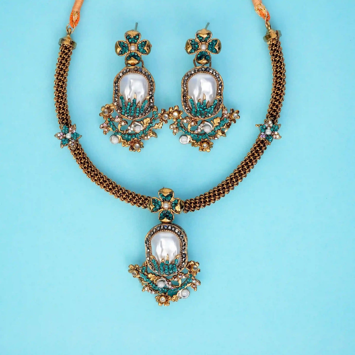 Jewelry set with necklace and earrings on a light blue background