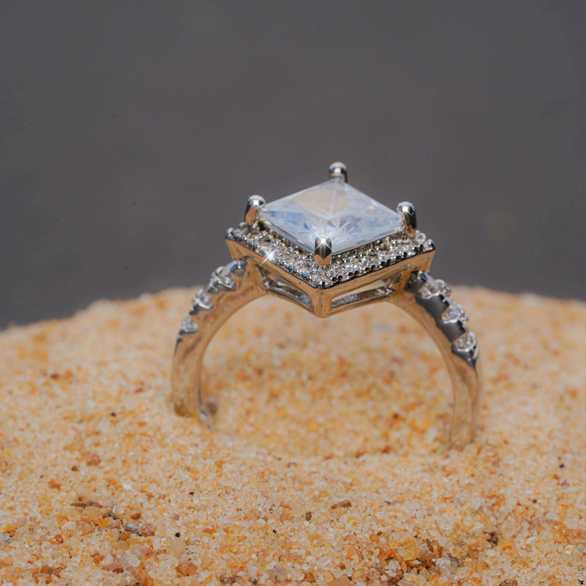 Gold ring with a diamond on a sandy surface