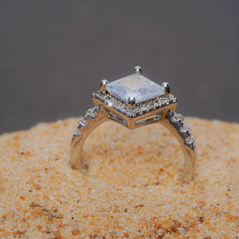 Gold ring with a diamond on a sandy surface