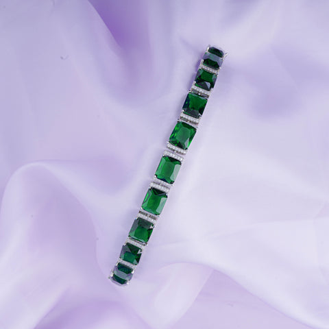 Green gemstone bracelet on a purple fabric background