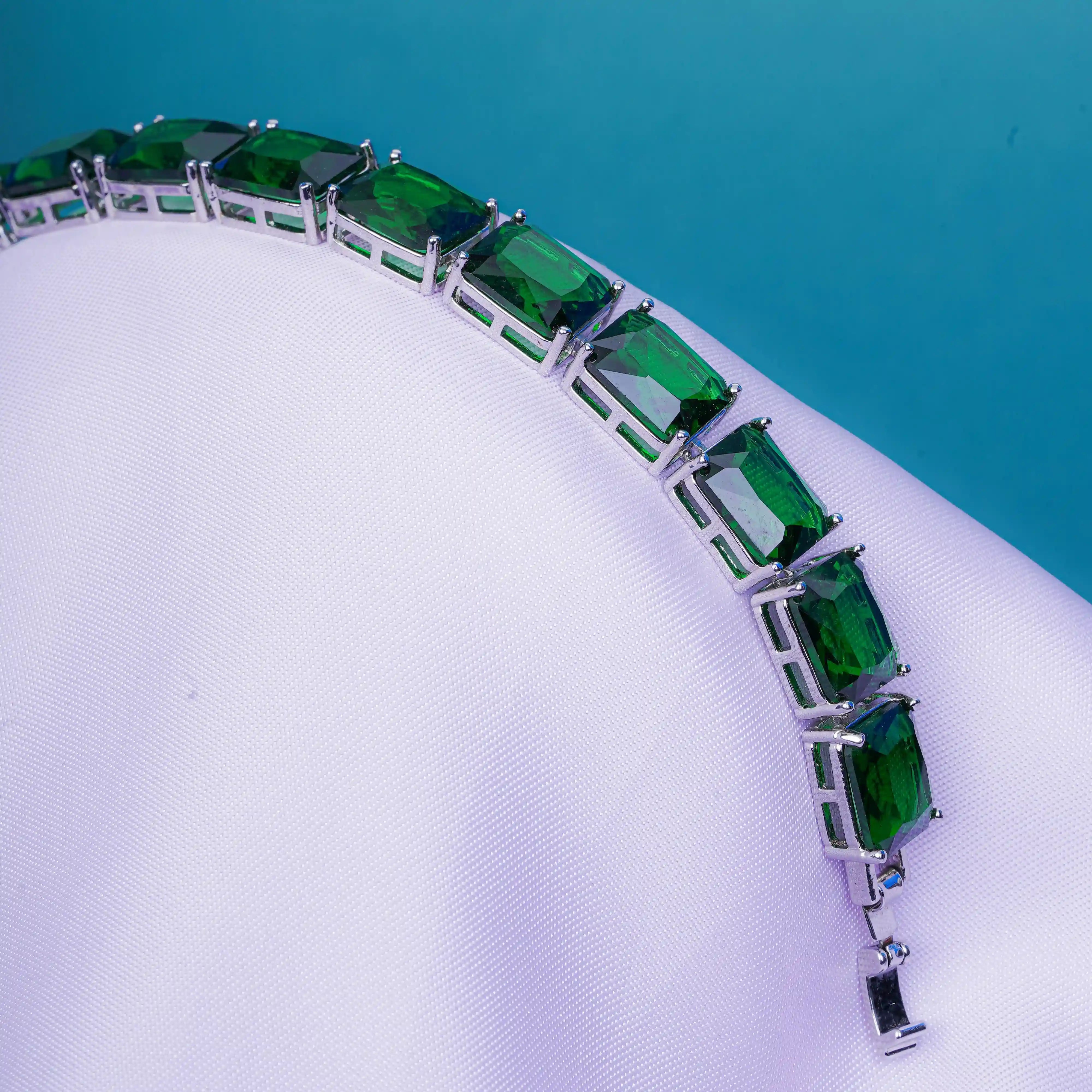 Green gemstone bracelet on a white and blue background