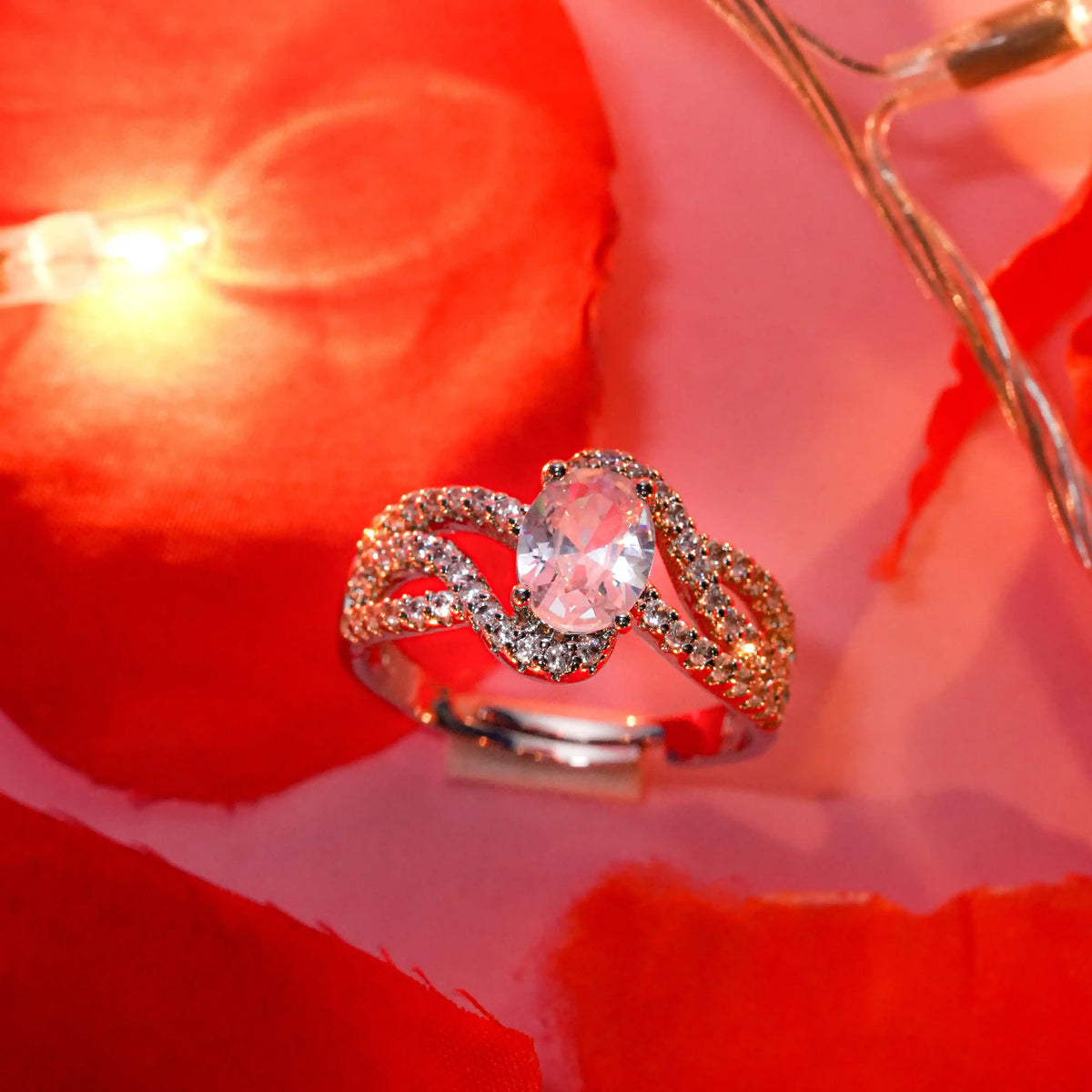 Silver ring with a pink gemstone on a red rose background